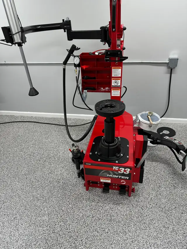The red Hunter tire changer on the shop's flake epoxy floor